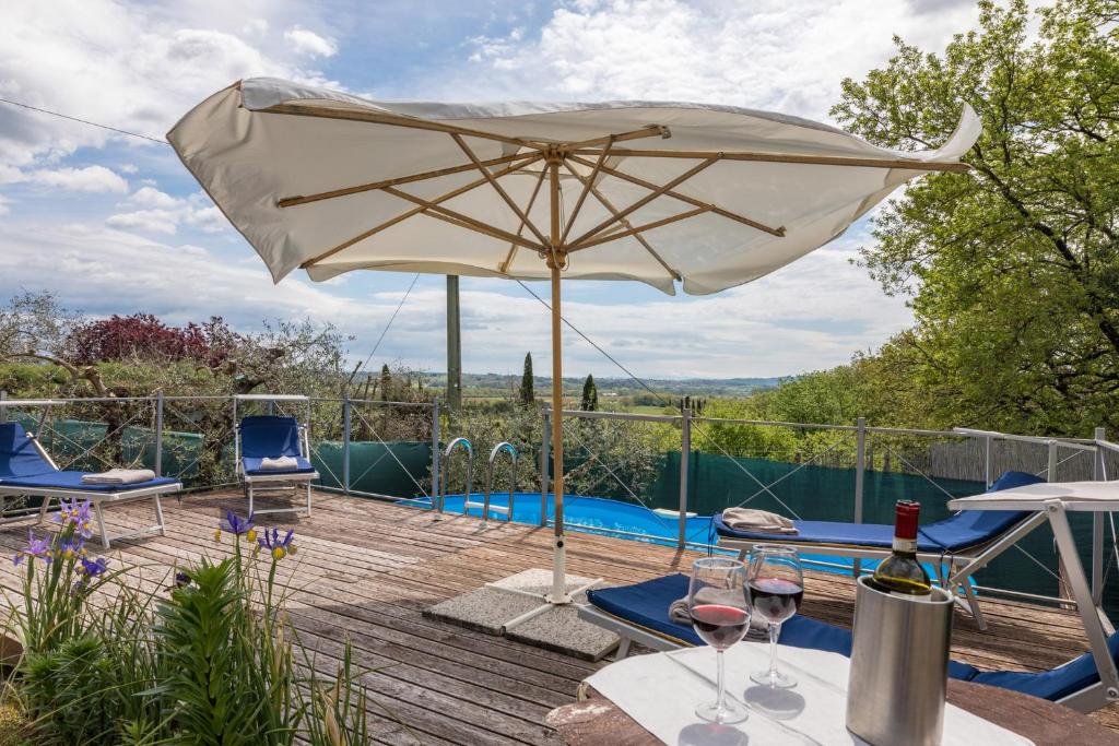 eine Terrasse mit einem Sonnenschirm und einem Pool in der Unterkunft Casa vacanze San Giusto in Sovicille