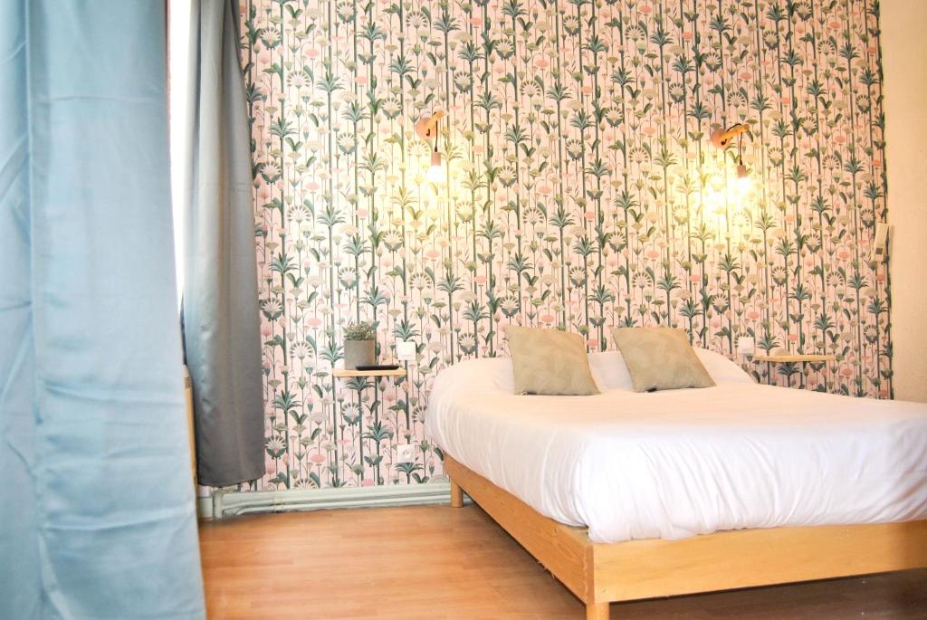 a bedroom with a bed with a floral wallpaper at Hôtel le Thurot in Dijon