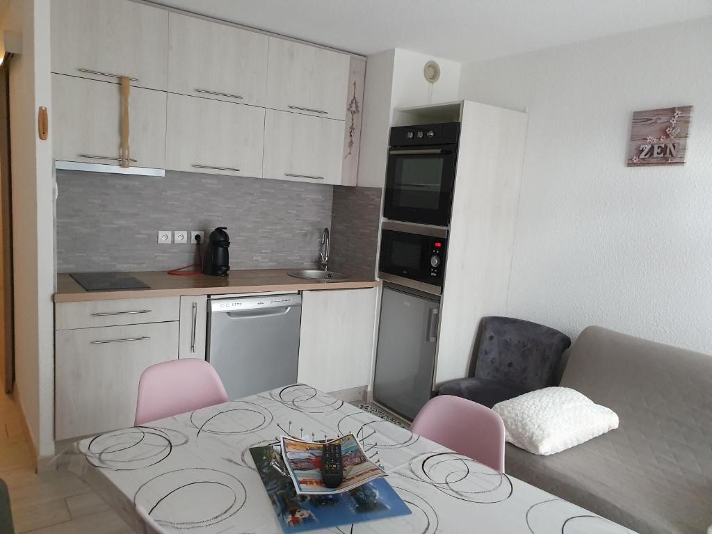 - une petite cuisine avec une table et des chaises dans la chambre dans l'établissement apt cosy, 4 pers, plein centre ville, parking offert, à Font-Romeu-Odeillo-Via