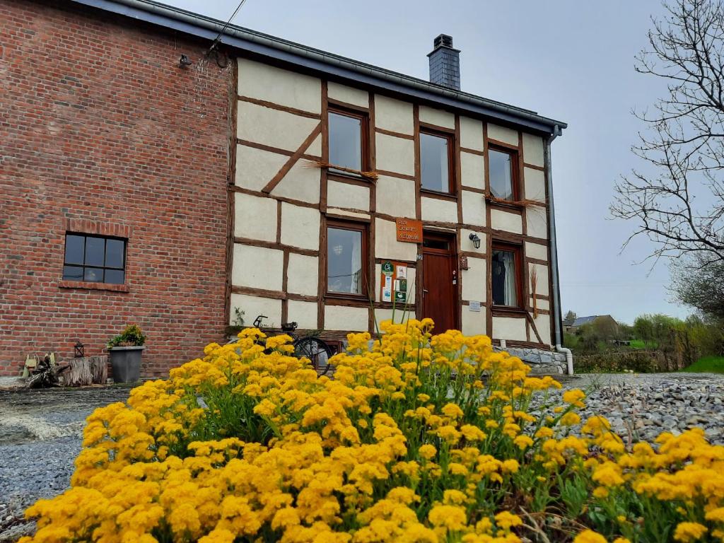 een gebouw met gele bloemen ervoor bij Aux Saveurs d'Enneille in Durbuy