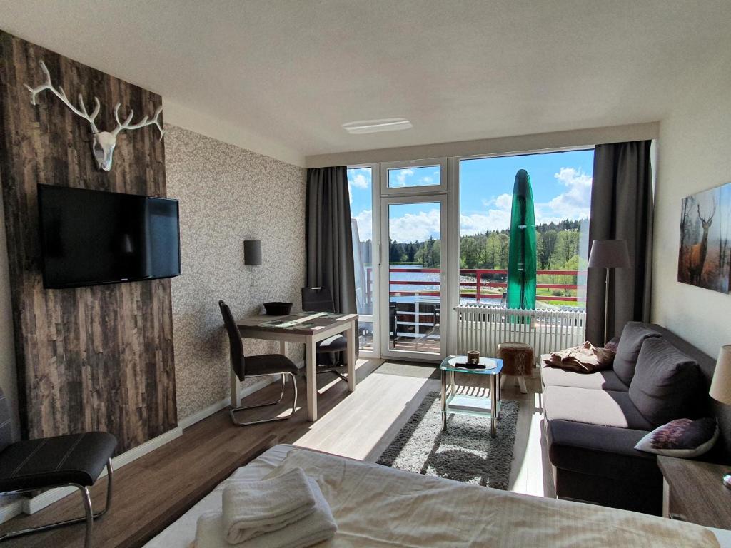 ハーネンクレー・ボックスヴィーゼにあるHarz Dream - Vier Jahreszeitenのベッドとデスクが備わるホテルルームです。