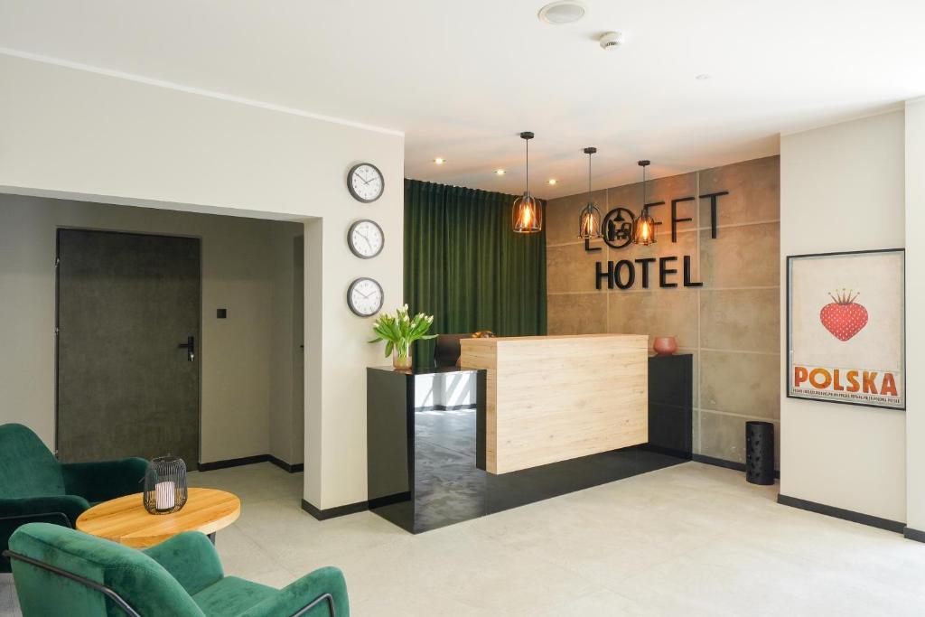 a hotel lobby with a reception desk and chairs at Lofft Hotel in Ciechanów