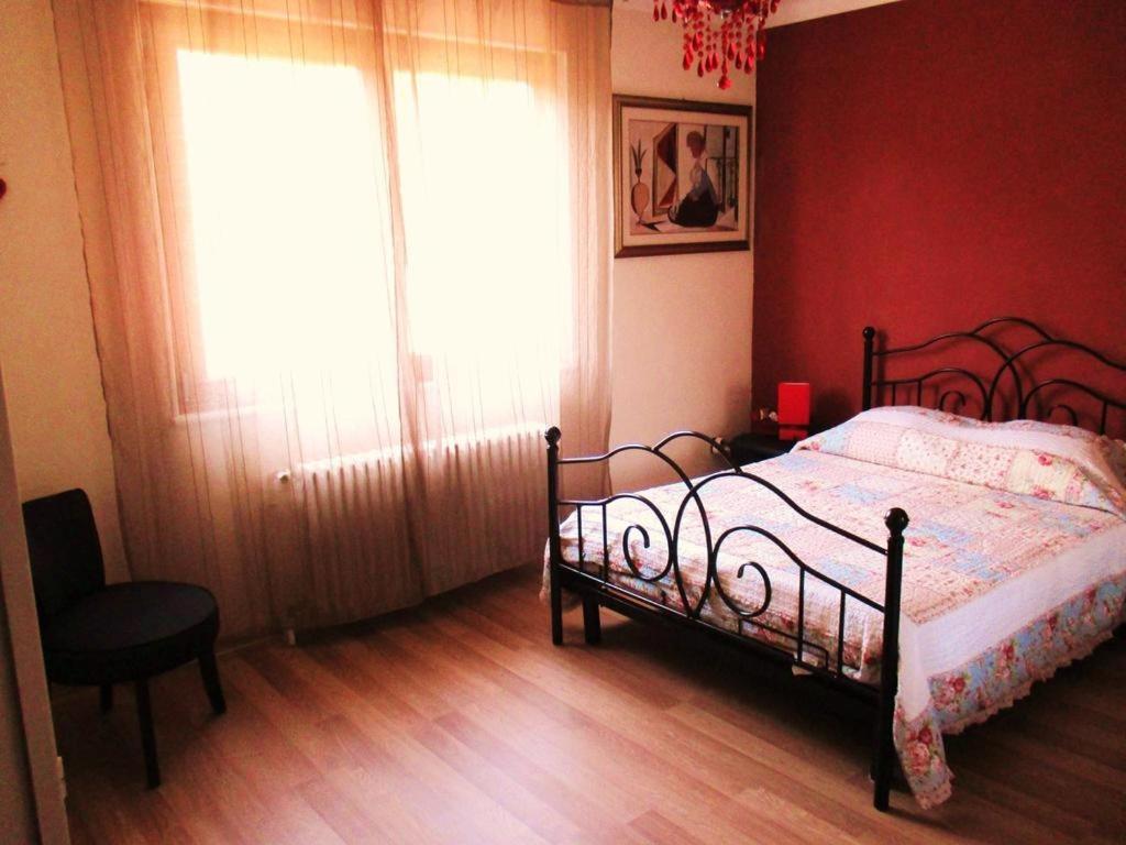 a bedroom with a bed and a window and a chair at Colmar , Séjour calme chez l'habitant in Colmar