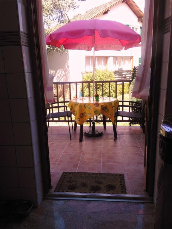a table with a pink umbrella on a patio at Colmar , Séjour calme chez l&#39;habitant in Colmar