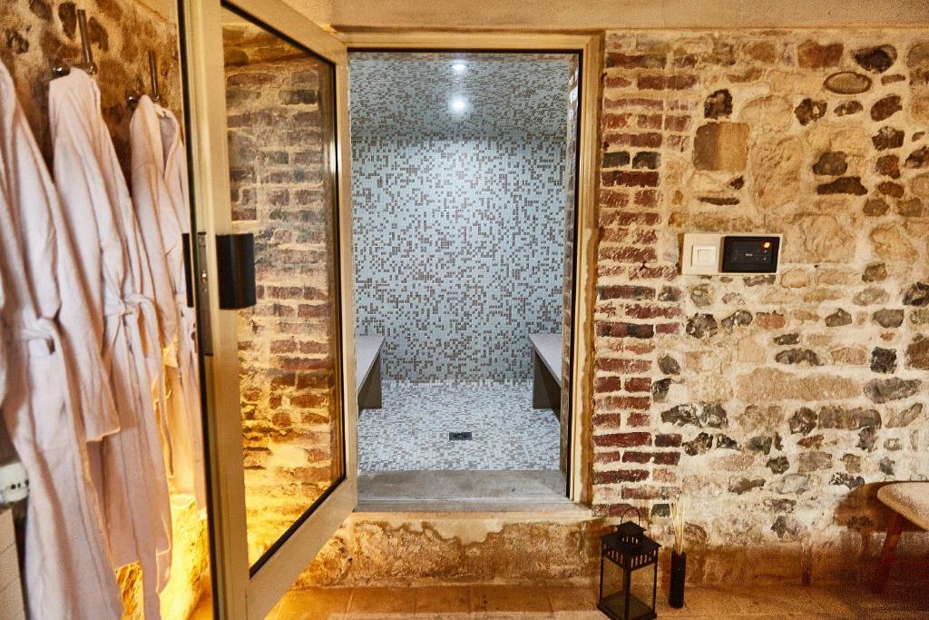 a bathroom with a shower in a brick wall at Demeure de Manneville - SPA - 1Km des plages de Cabourg in Dives-sur-Mer