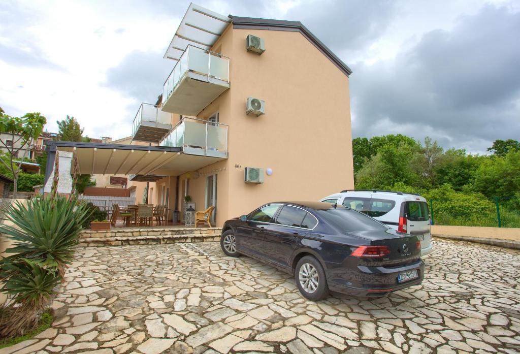 a black car parked in front of a house at Malinska -Krk in Malinska