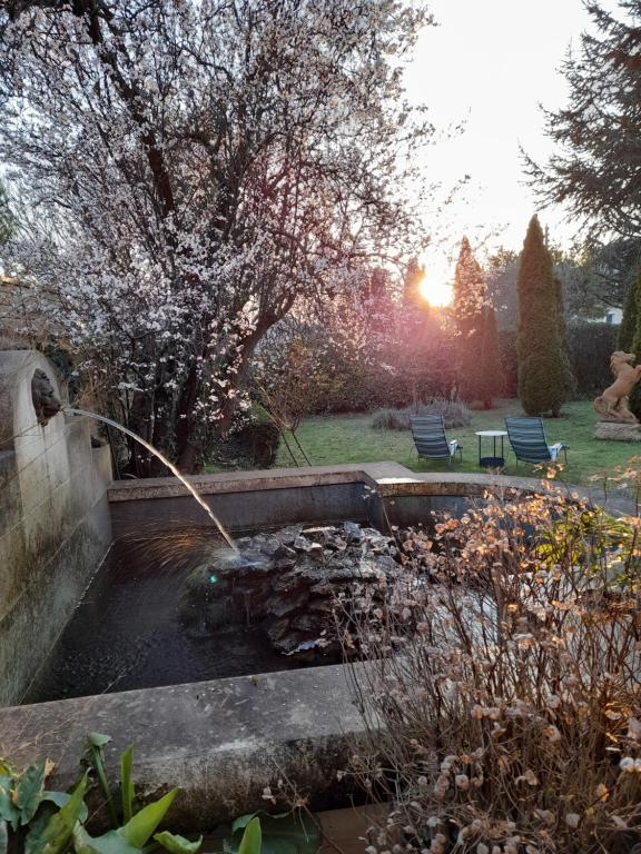 a garden with a water fountain in a yard at Demeure de Manneville - SPA - 1Km des plages de Cabourg in Dives-sur-Mer