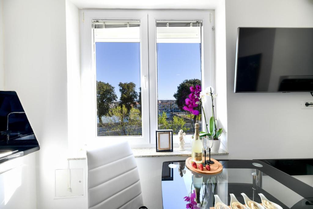 eine Küche mit einem Fenster und einem Tisch mit Blumen in der Unterkunft Lauris Luxury Apartment Zadar in Zadar