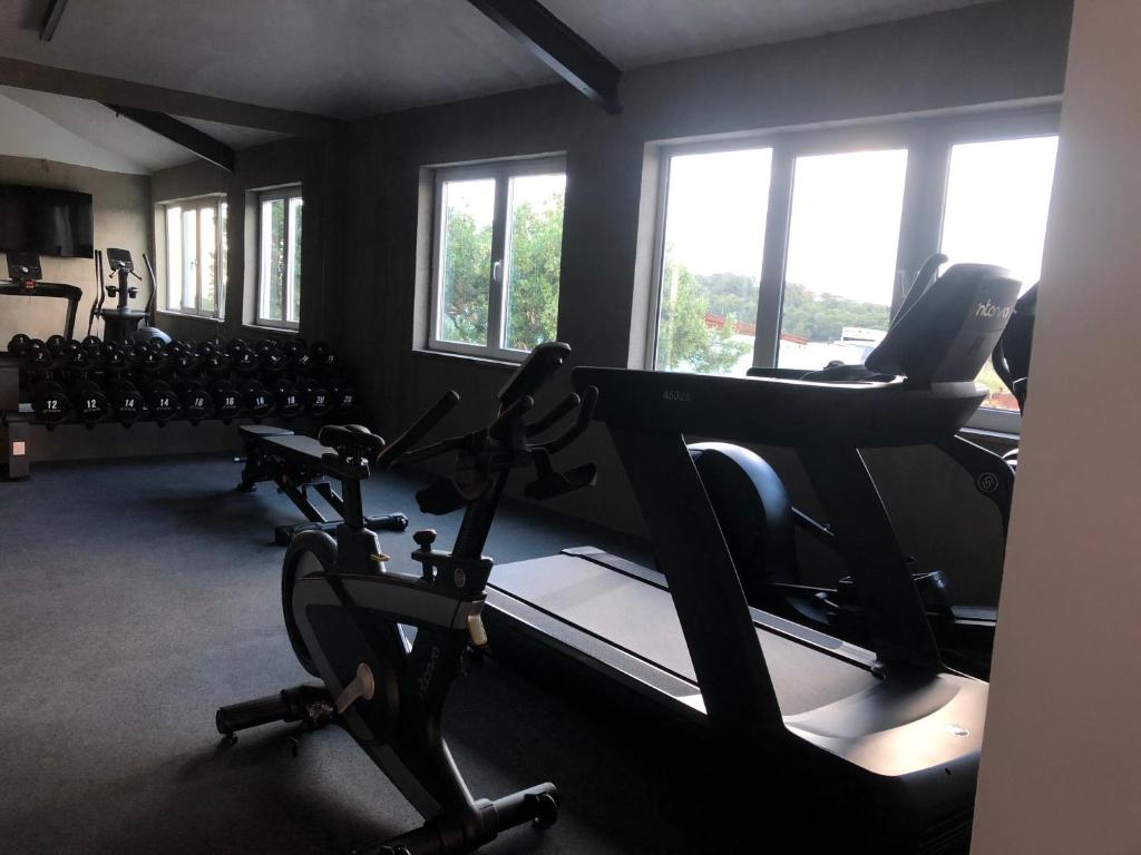 a gym with treadmills and ellipticals in a room with windows at Dela in Hvar