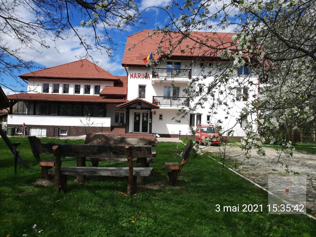 a house with a bench and a building at Pensiunea Marina in Bran