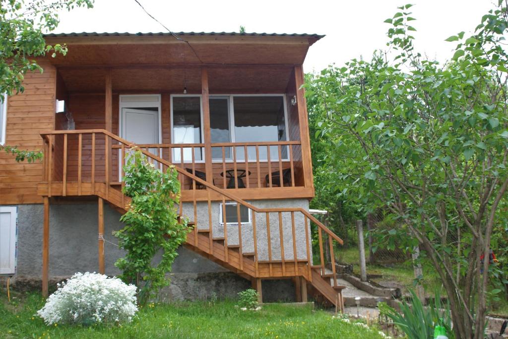 a house with a wooden deck with a porch at Cottage in Tʼelavi
