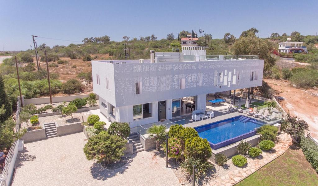 z góry widok na dom z basenem w obiekcie Chloe Luxury Villas w mieście Protaras