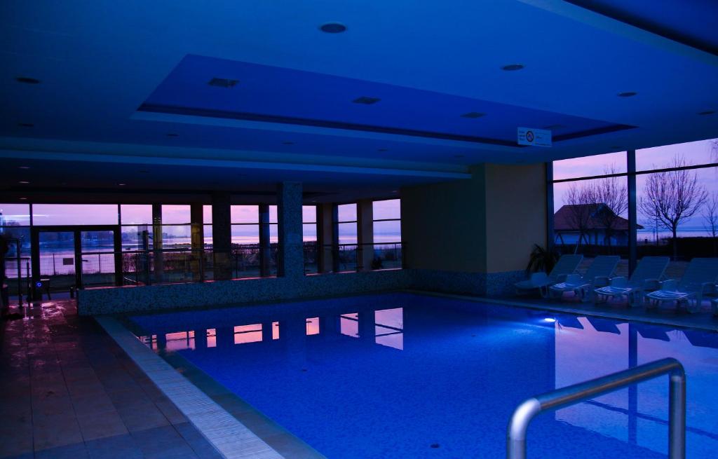 a large swimming pool in a building with blue lights at Club 218 Wellness Luxus Apartman in Siófok