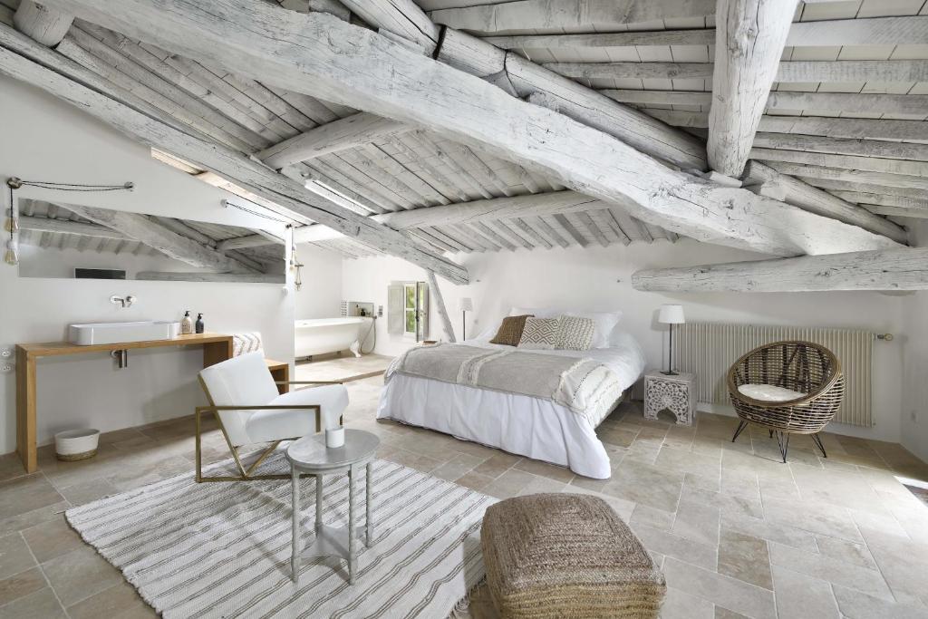 een slaapkamer met een bed en een tafel en stoelen bij La Maison de Lourmarin in Lourmarin