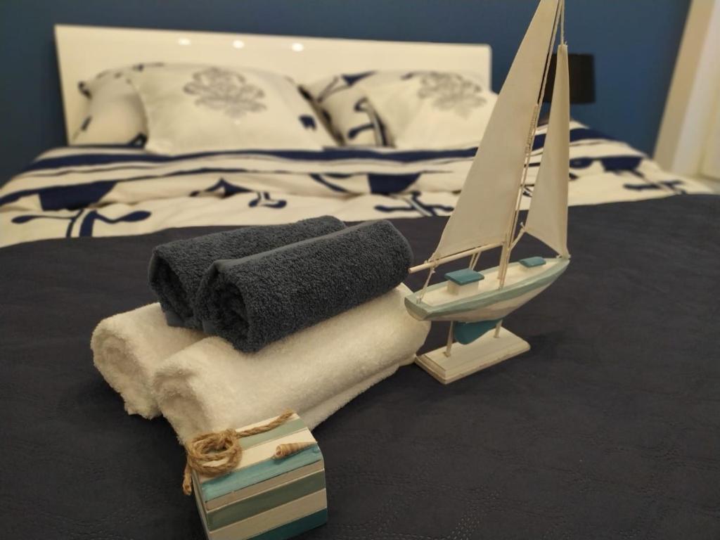 Aqua Blue Apartament في ريدا: سرير عليه مناشف و قارب العاب