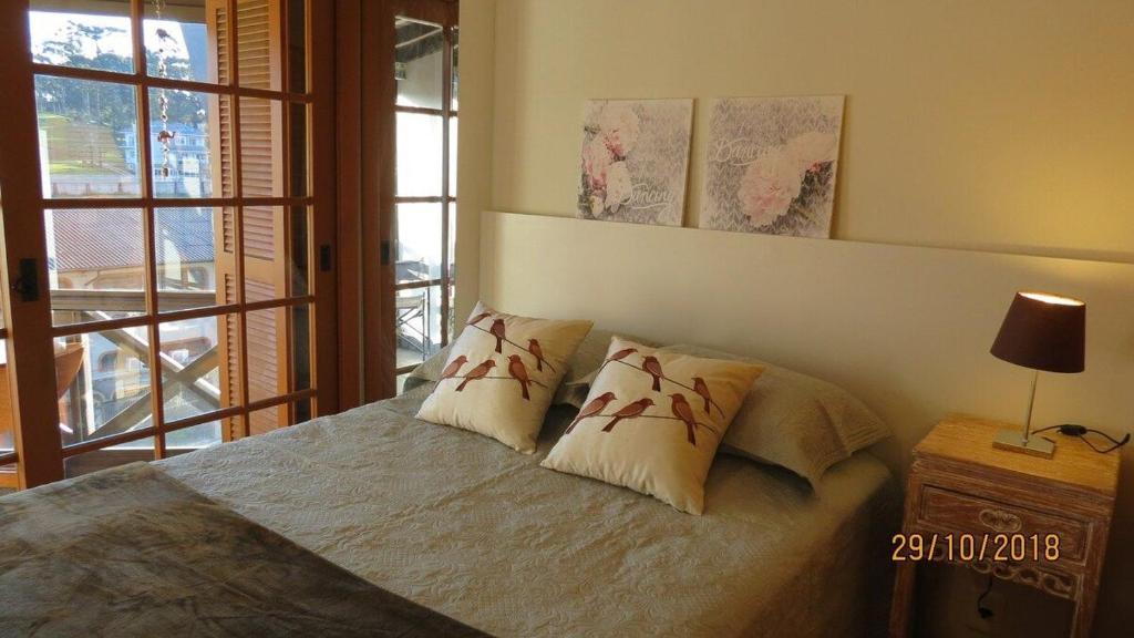 1 dormitorio con 1 cama con 2 almohadas en Aconchegante Apto no Centro de Canela, en Canela
