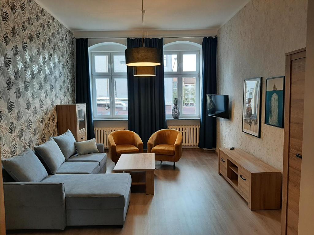sala de estar con sofá y mesa en Apartamenty 21 Stare Miasto en Szczecin