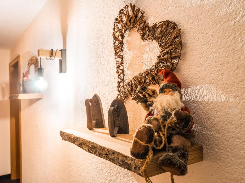 ein Santa Claus Ornament auf einem Regal mit einem Herz in der Unterkunft Haus Stüttler/Duchscherer in Schruns-Tschagguns