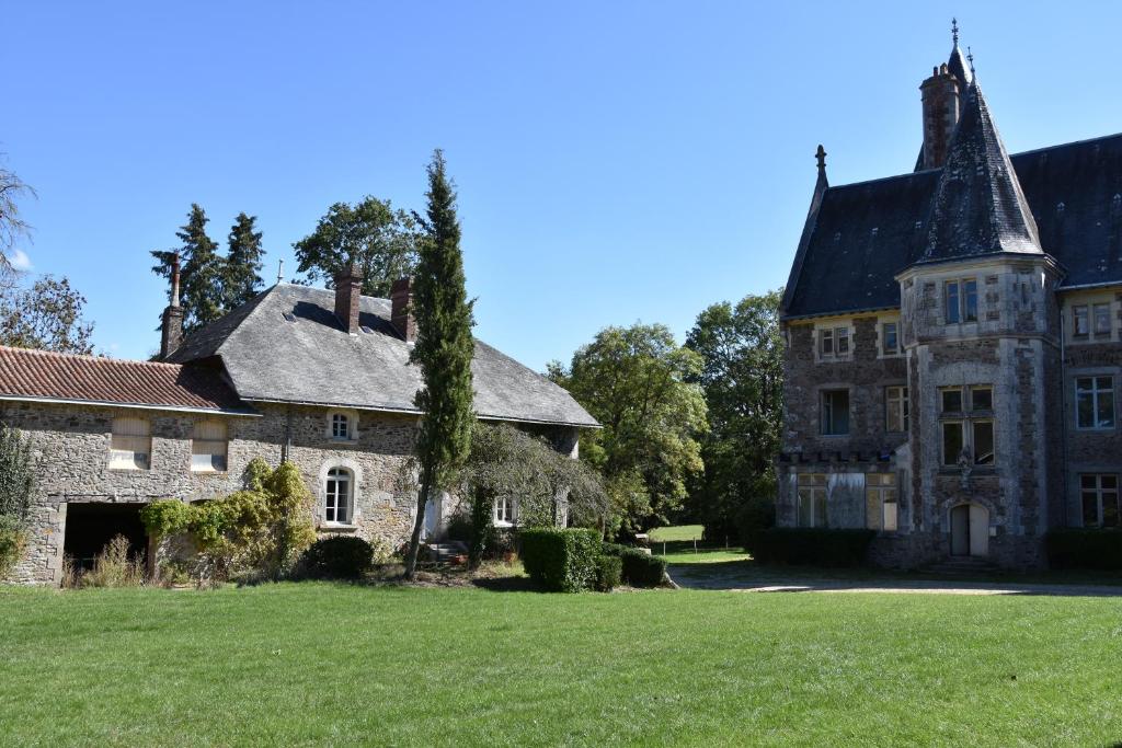 une ancienne maison en pierre avec une grande cour dans l'établissement Gîte proche Puy duFou, à Mauléon