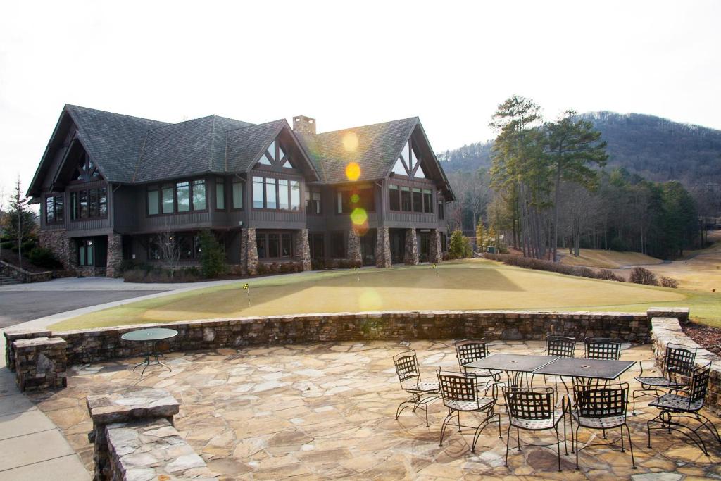 a large house with a patio with tables and chairs at Golf Club Villas in Marblehill