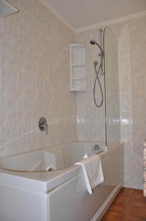 a bathroom with a white tub and a shower at Hotel Bristol in Tirrenia