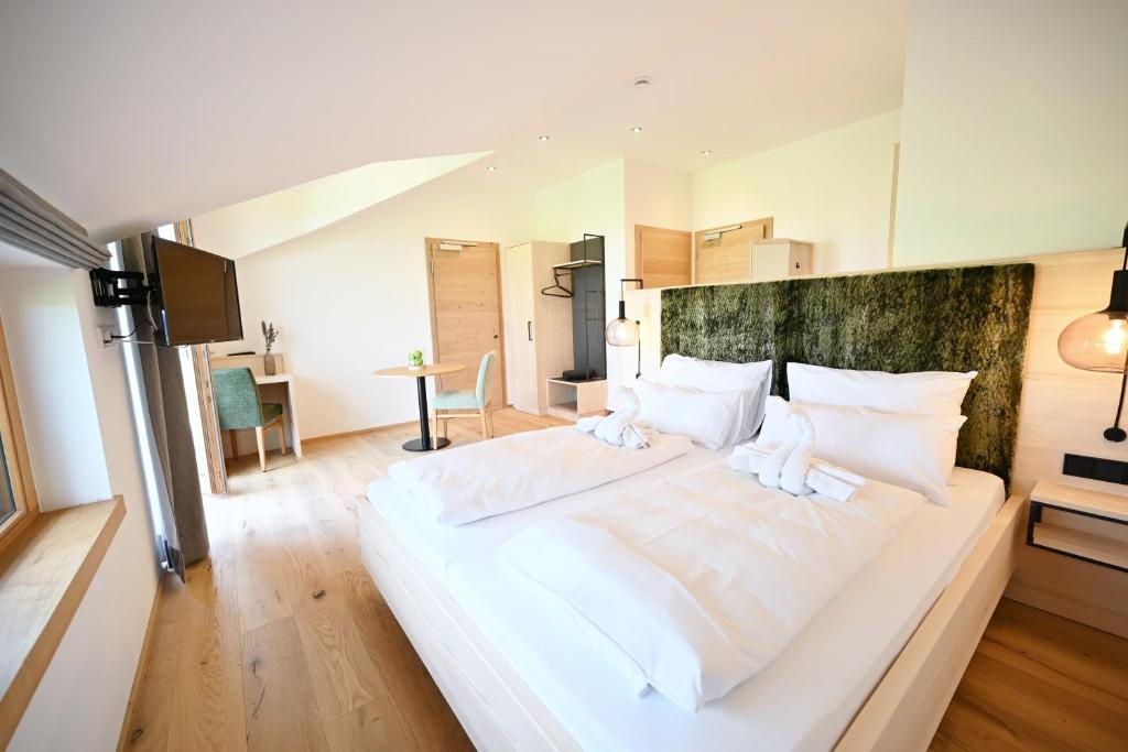 a large white bed with white pillows in a room at Danner-Hof in Kochel