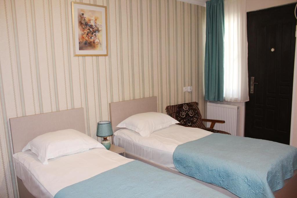 a room with two beds and a chair at Guest House Old Tiflis 5 in Tbilisi City