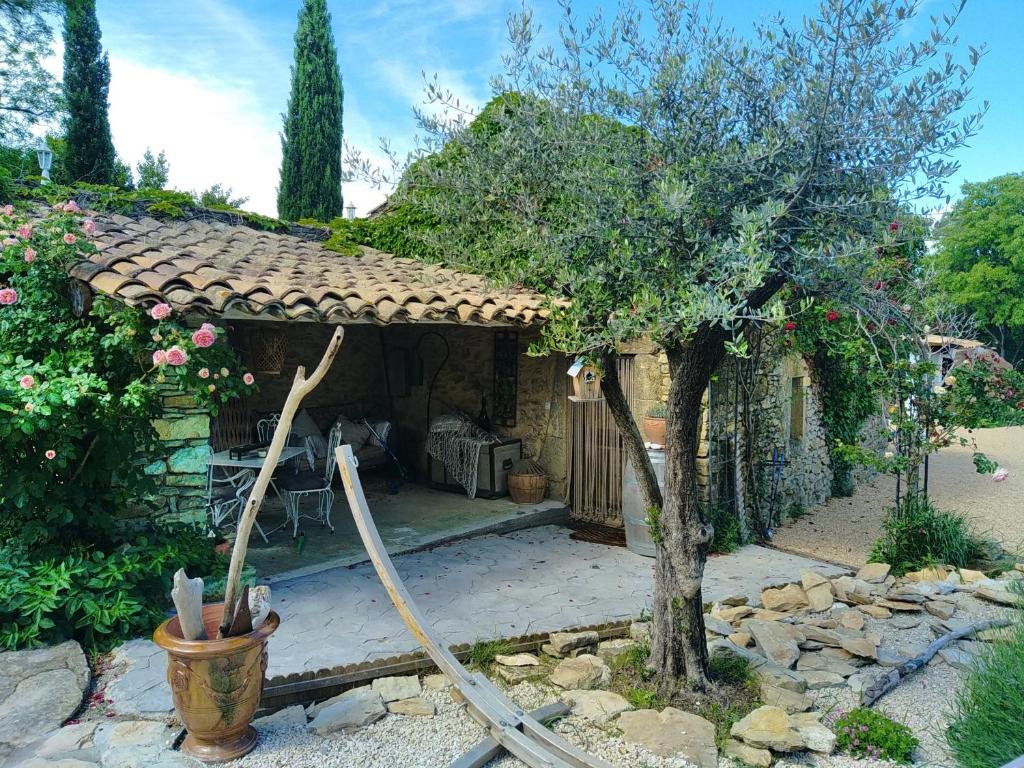 un jardin avec une maison avec un tuyau dans l'établissement Gites de charme en provence occitane, à Saint-André-dʼOlérargues