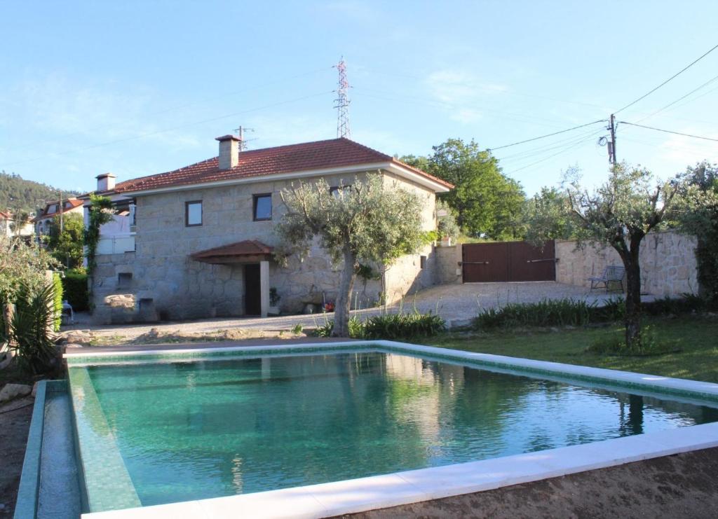 a house with a swimming pool in front of a house at Bernardes House in Castelo de Paiva