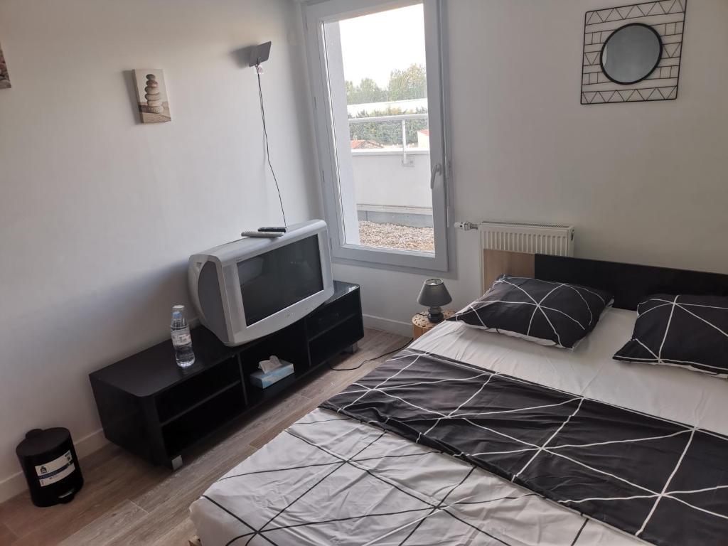 sypialnia z łóżkiem z telewizorem w obiekcie Private room CDG airport Parc Expo w Villepinte