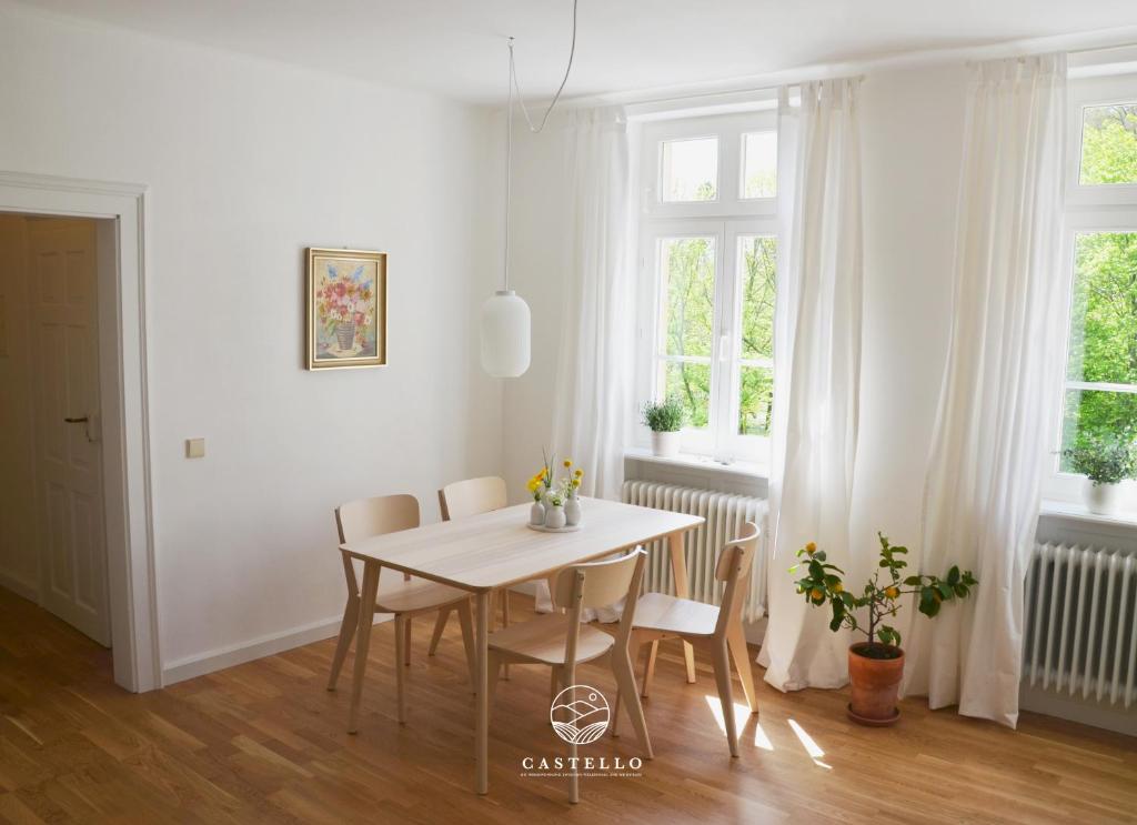 une salle à manger blanche avec une table et des chaises dans l'établissement Die Gründerzeitvilla zwischen Weinstrasse und Pfälzer Wald, à Bad Bergzabern