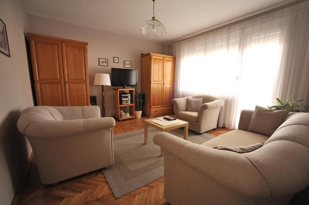 皮羅特的住宿－Apartman Rada，客厅配有两把椅子和电视