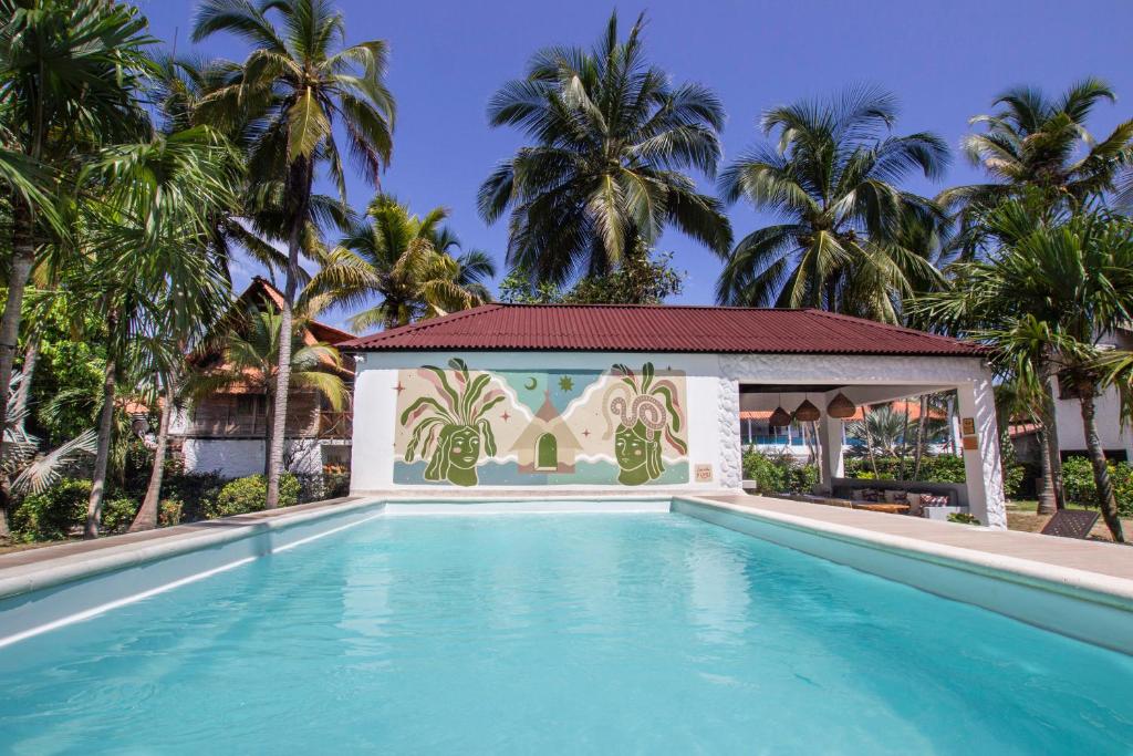 a swimming pool with a gazebo and palm trees at Selina Palomino in Palomino