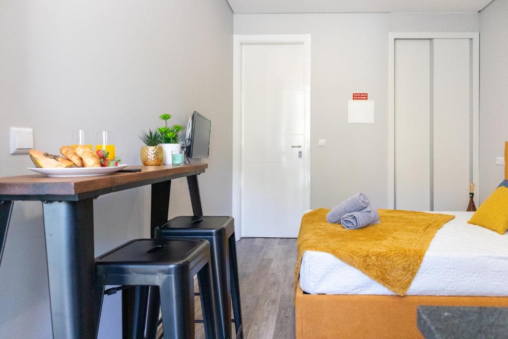 a bedroom with a bed and a desk with a plate of bread at Marques studio in Porto da Cruz