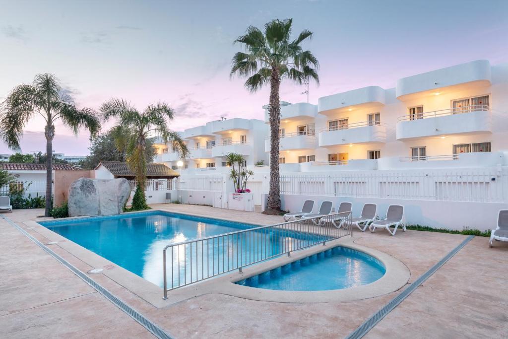 una piscina frente a un edificio en Olive Beach Apartamentos en Puerto de Alcúdia