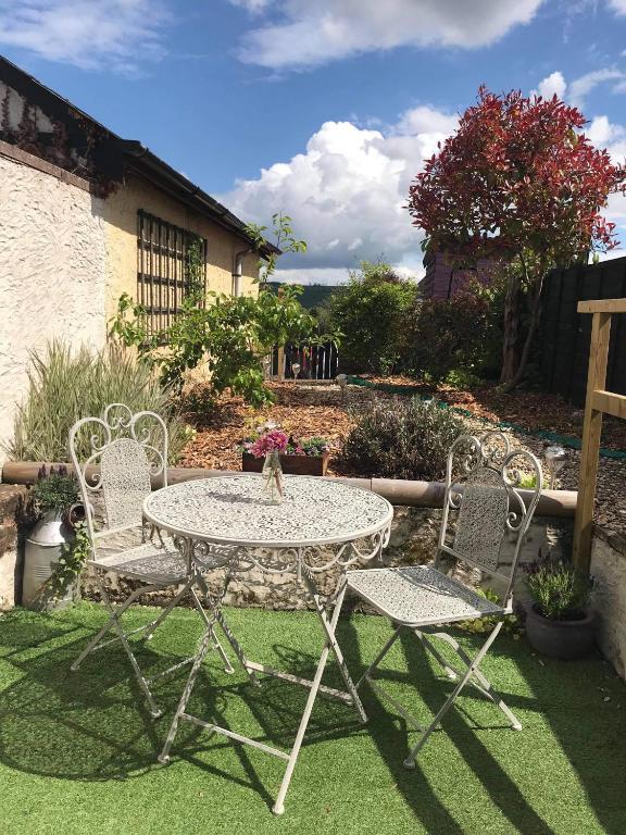 a patio table and two chairs on a lawn at Lavender Cottage in Presteigne
