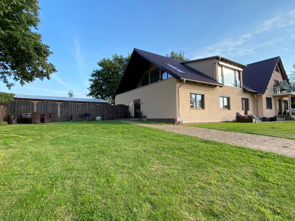 uma casa com um relvado verde em frente em Ferienwohnung PuraVida Ostsee 5B em Bastorf