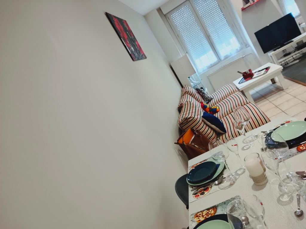 una sala de estar con una mesa con gafas. en Blanc de Tardy en Saint-Étienne