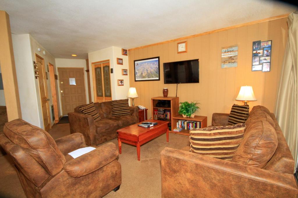 a living room with leather furniture and a flat screen tv at Sierra Park Villas #29 in Mammoth Lakes