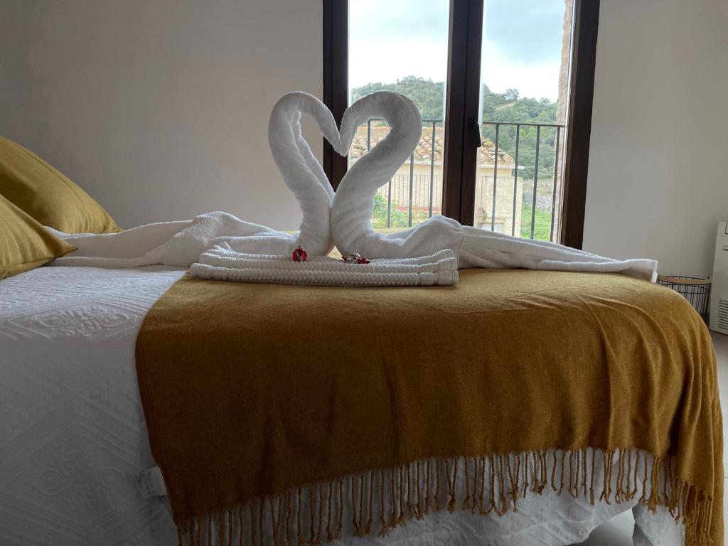 two white swans sitting on top of a bed at CASA LA ABUELA in Olocau del Rey
