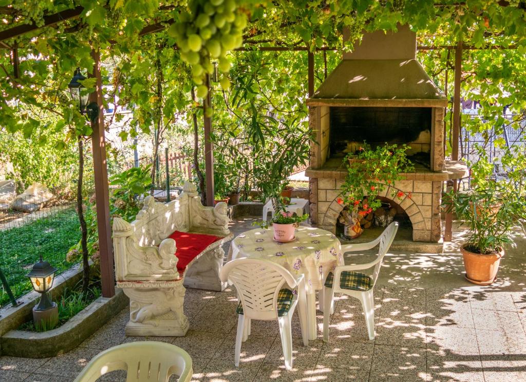 eine Terrasse mit einem Tisch, Stühlen und einem Kamin in der Unterkunft Gina in Rijeka