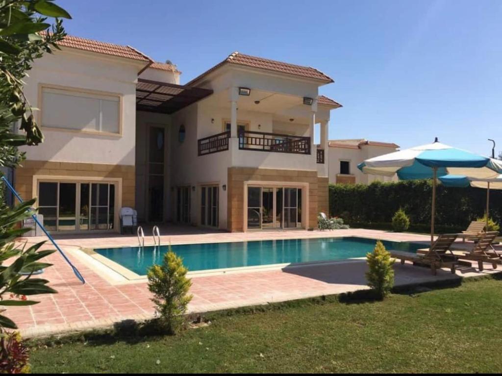 a villa with a swimming pool in front of a house at Relaxation Villa with private pool in Alexandria