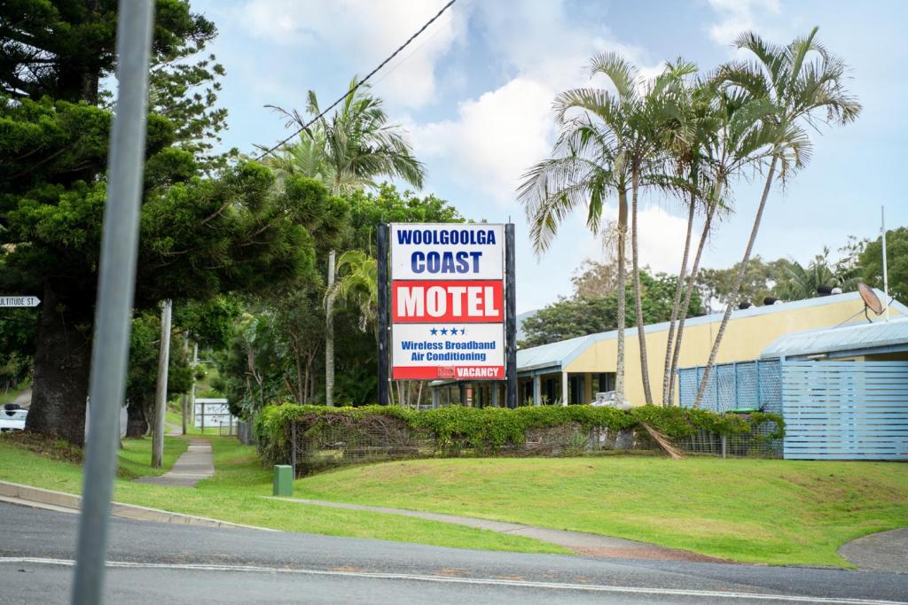 a sign for a motel on the side of a street at Woolgoolga Coast Motel in Woolgoolga