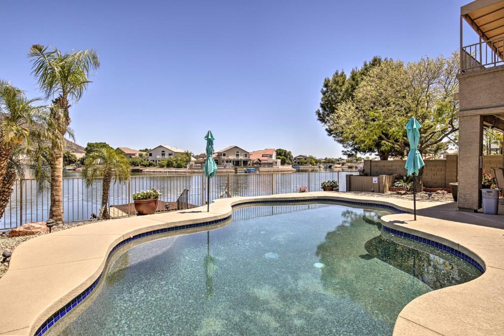 una piscina con recinzione e palme di Lakefront Glendale Getaway with Boat Dock and Pool! a Peoria