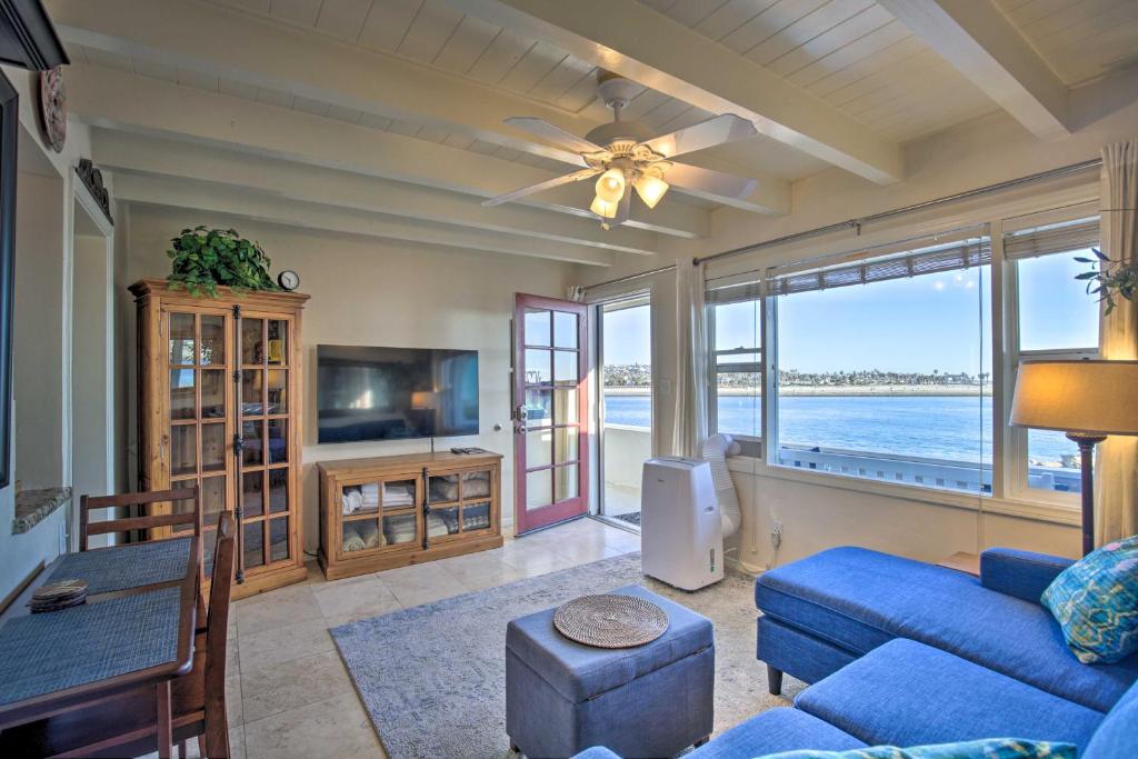 uma sala de estar com um sofá azul e uma televisão em Mission Point, San Diego Hub - 1 Block to Beach! em San Diego