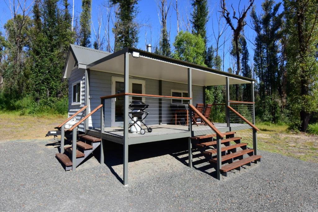 a tiny house with a porch and a staircase at Pindari Tiny Home Kangaroo Valley in West Cambewarra