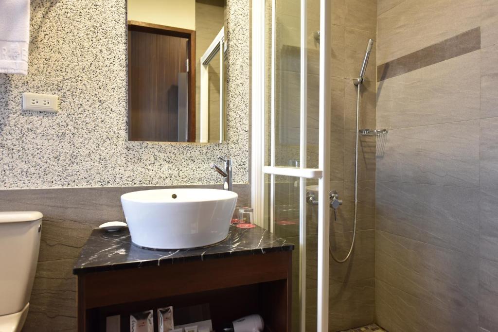 a bathroom with a sink and a shower at The Galerie Hotel in Taichung