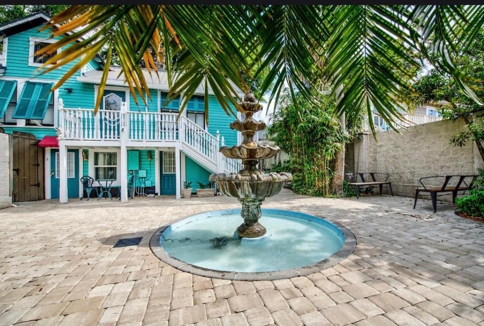 einen Brunnen in der Mitte eines Hofes mit einem Haus in der Unterkunft Peace & Plenty Inn Bed and Breakfast Downtown St Augustine-Adults Only in St. Augustine