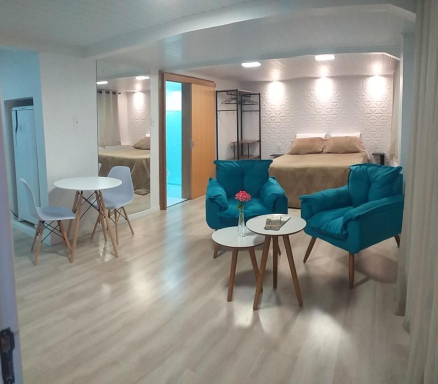 Sala de estar con 1 cama y 2 sillas y mesas en Pousada Bella Vista - Vale dos Vinhedos en Bento Gonçalves