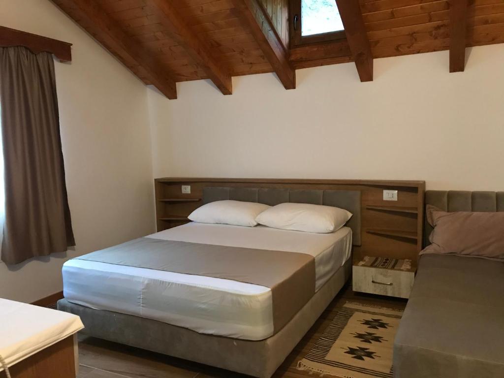 een slaapkamer met een bed en een bank bij Sofra Kelmendit in Tamarë